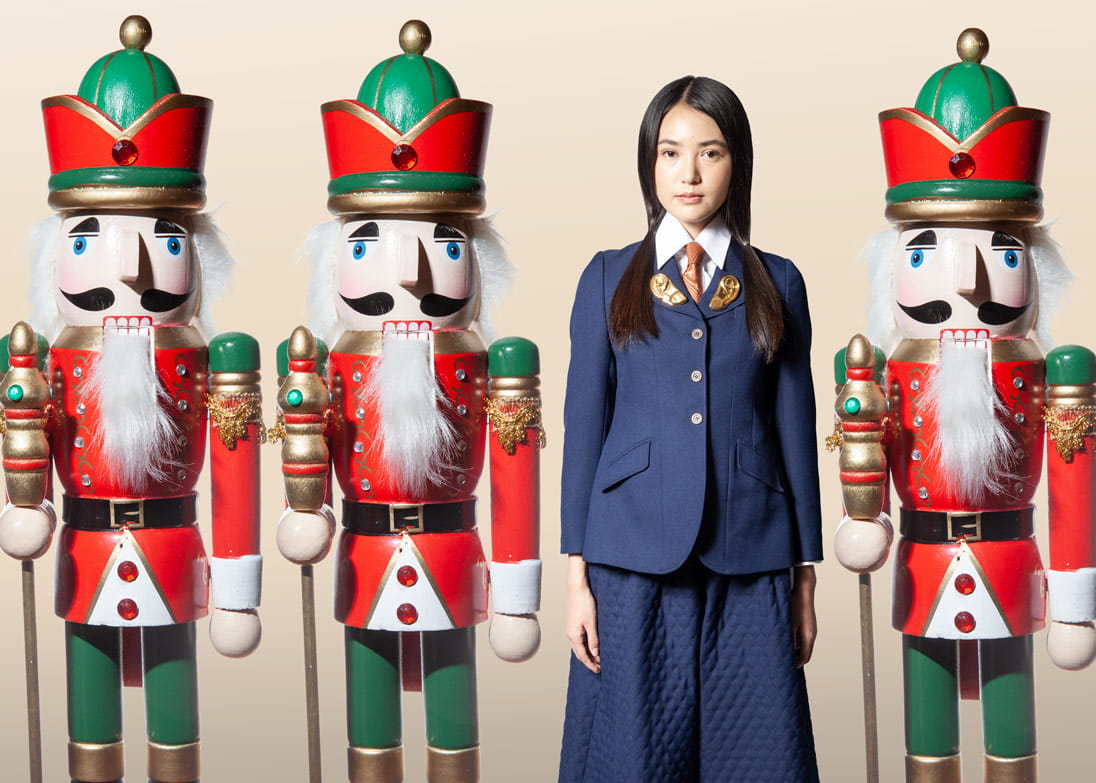 A model stands next to life-sized nutcracker dolls wearing Gucci