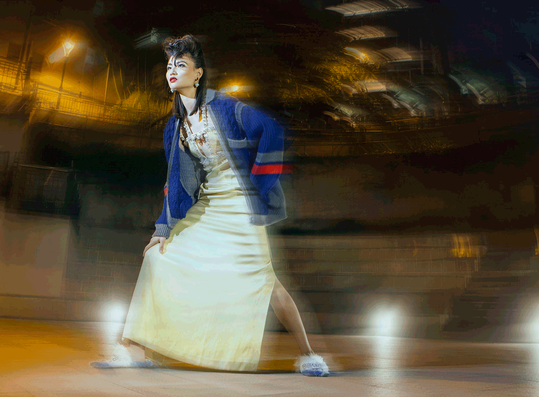 A model poses in a satin gown and cardigan by Miu Miu in a Hong Kong amphitheatre
