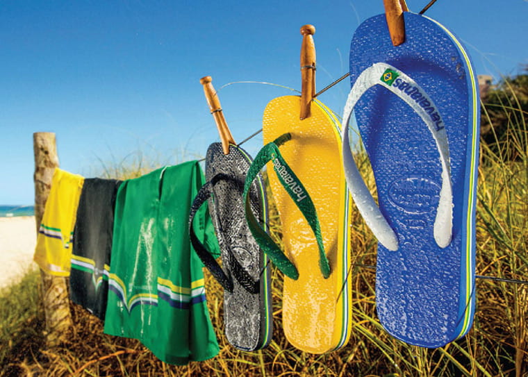 Havaianas hanging on a fence at a beach