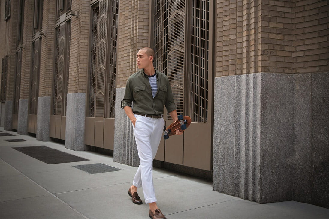 A man with a skateboard wearing a contemporary look from Brooks Brothers