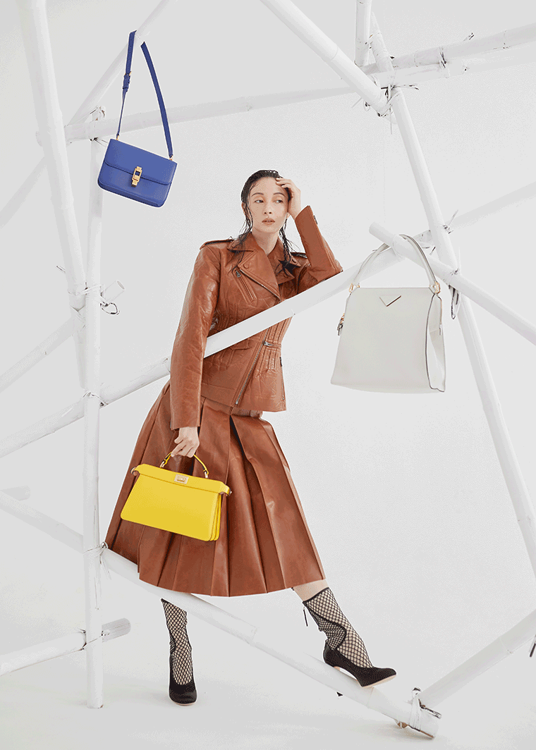 A model poses in Fendi, with handbags from Fendi, Prada and Saint Laurent
