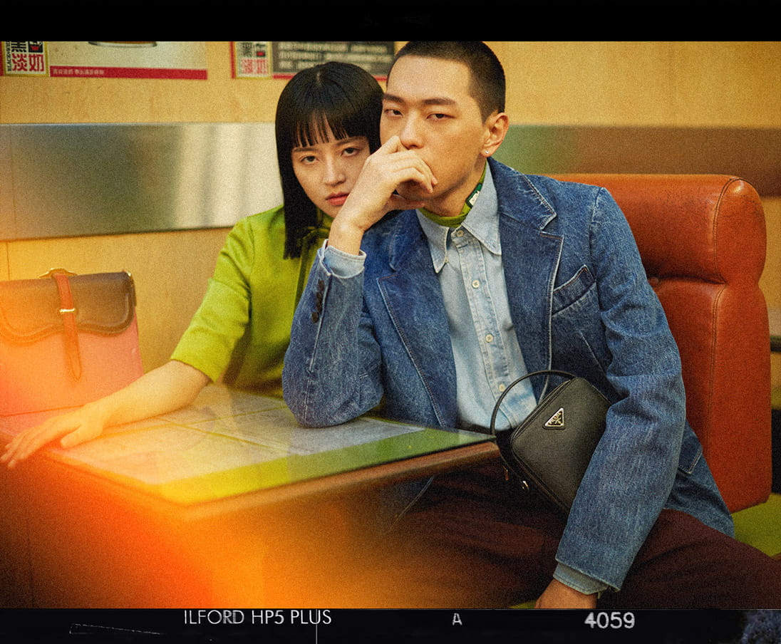 Models pose in a cafe wearing the latest looks from Prada