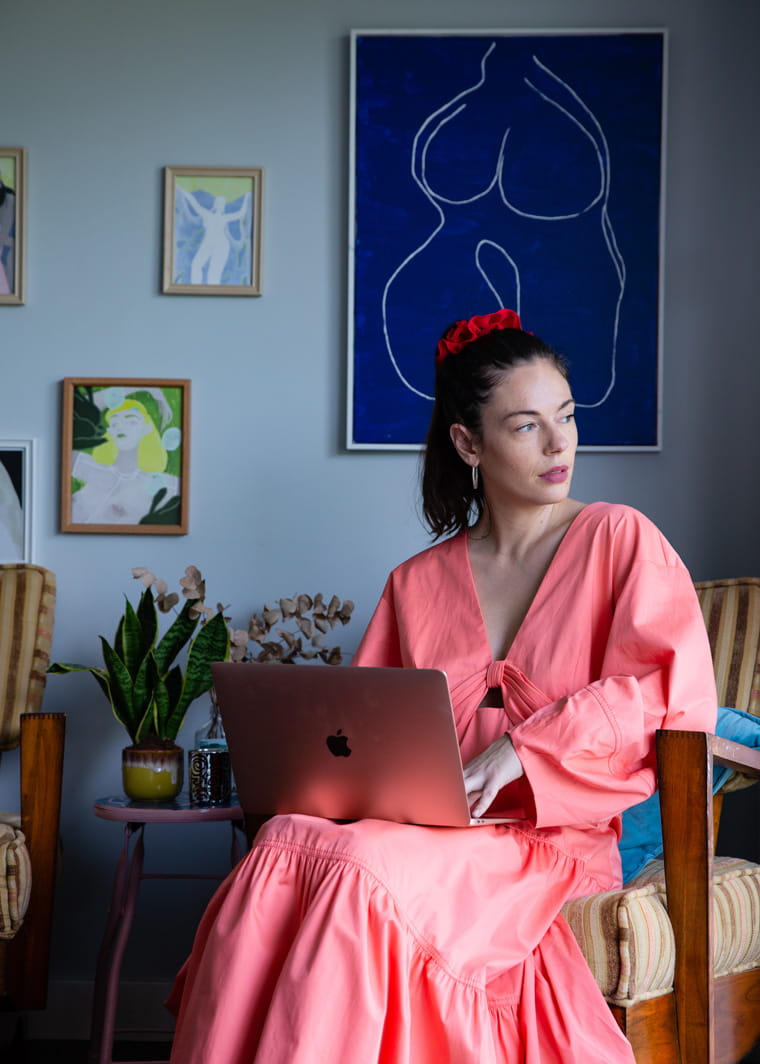 Olivia Cotes-James of LUÜNA naturals sits in front of her artwork collection