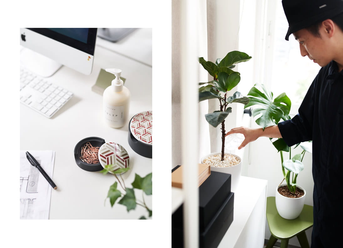 A table and a man water the plants in the office