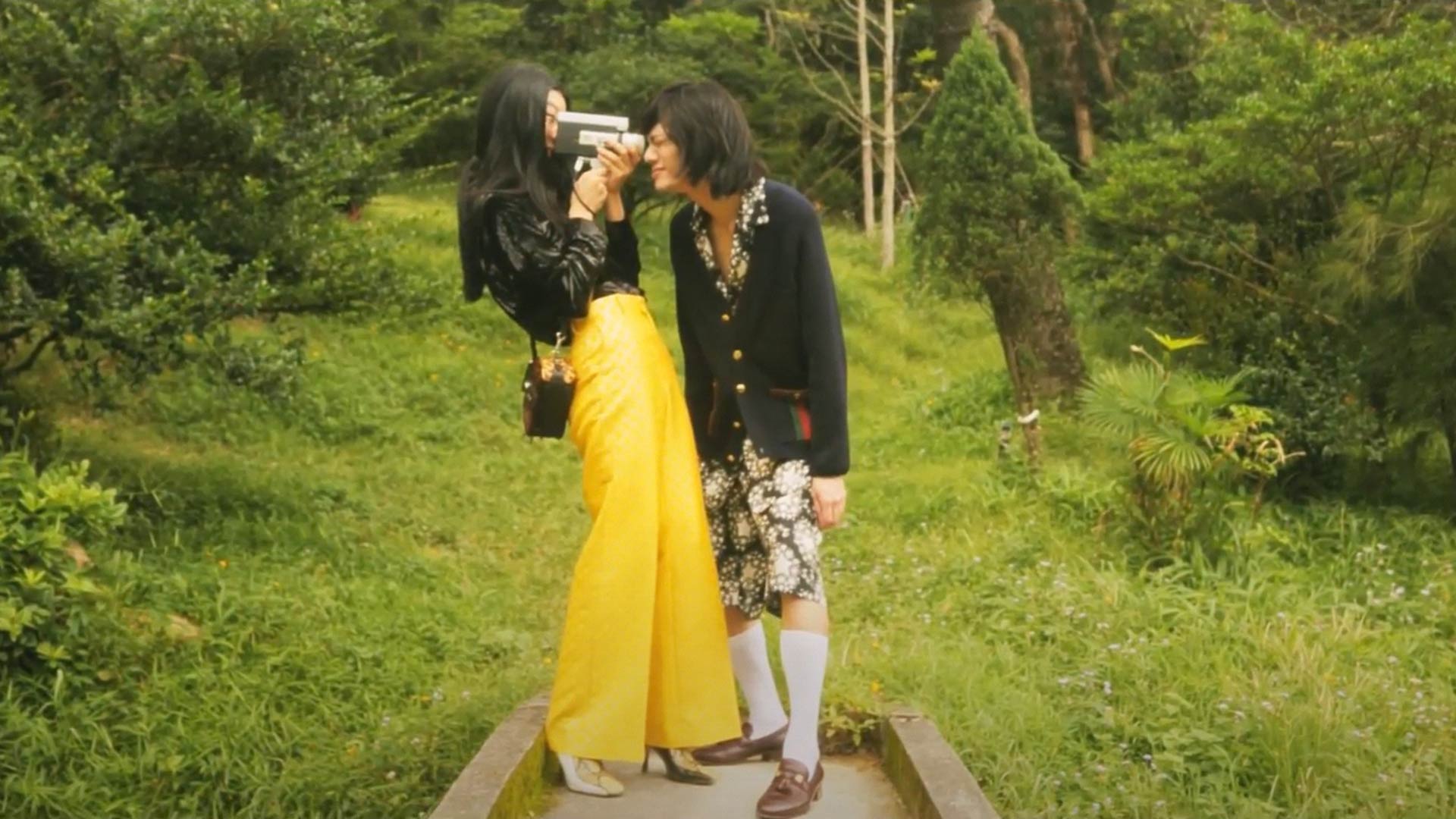 Male and female fashion models in a park