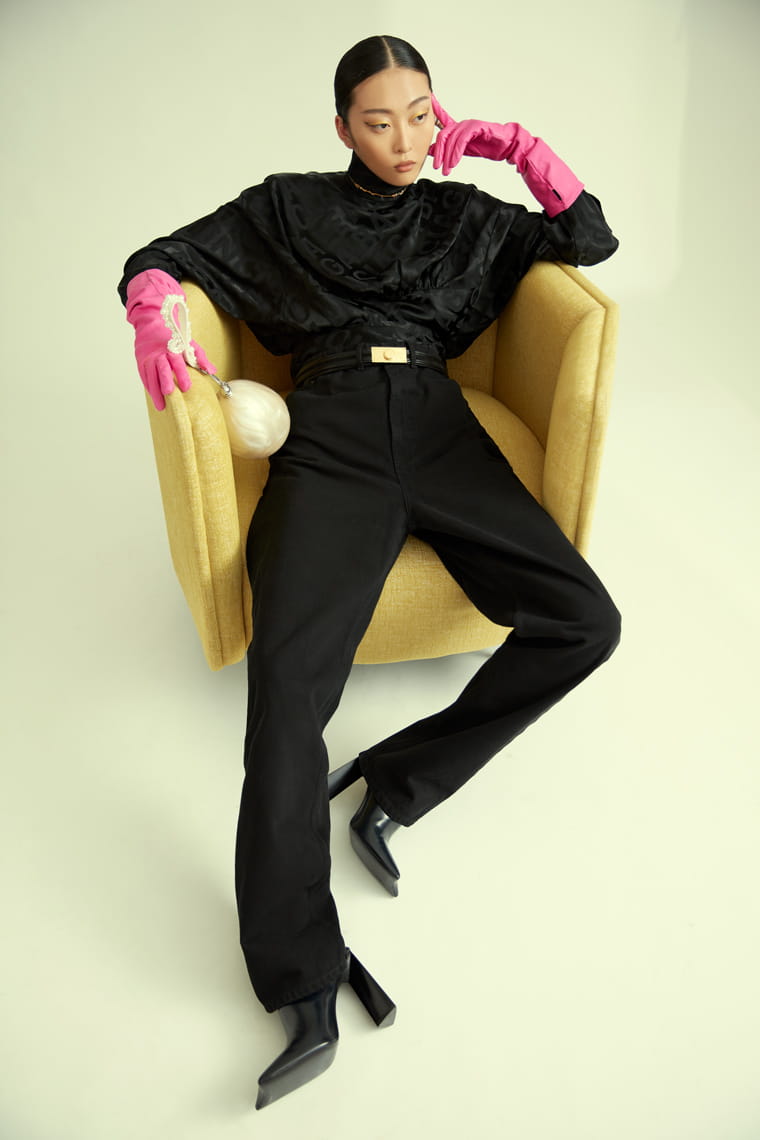 A model poses in Louis Vuitton, Balenciaga Versace and Simone Rocha