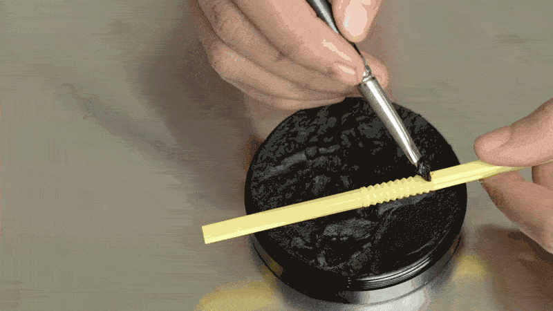 Mixing black eyeshadow with a touch of black acrylic paint to create a deep paste and using a firm shading brush to apply the mixture
