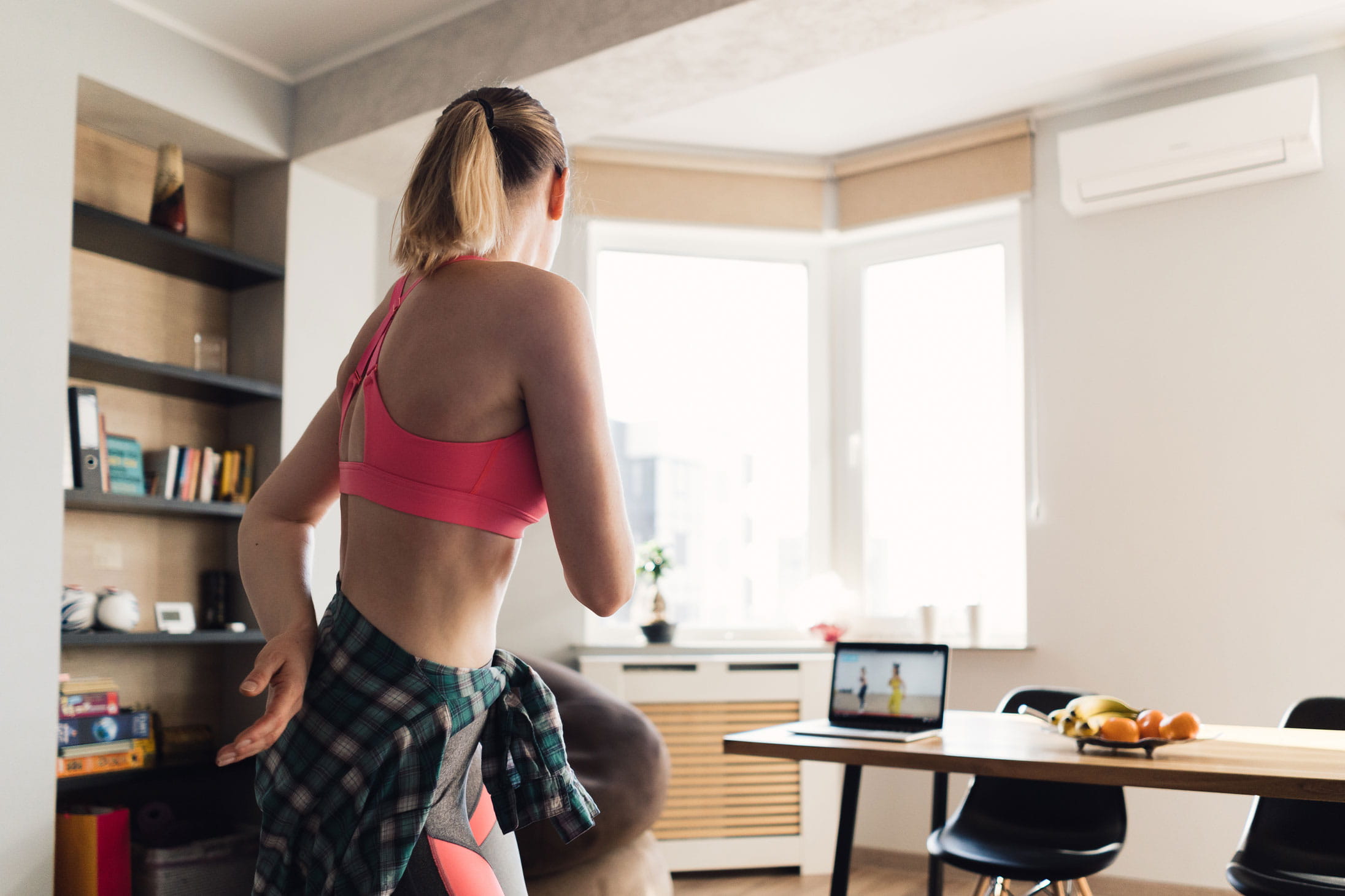 A woman doing an online exercise class from home
