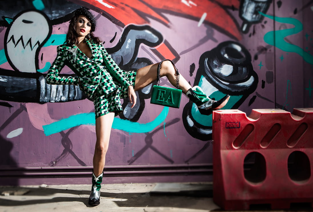 A model poses in front of graffiti wearing Emporio Armani