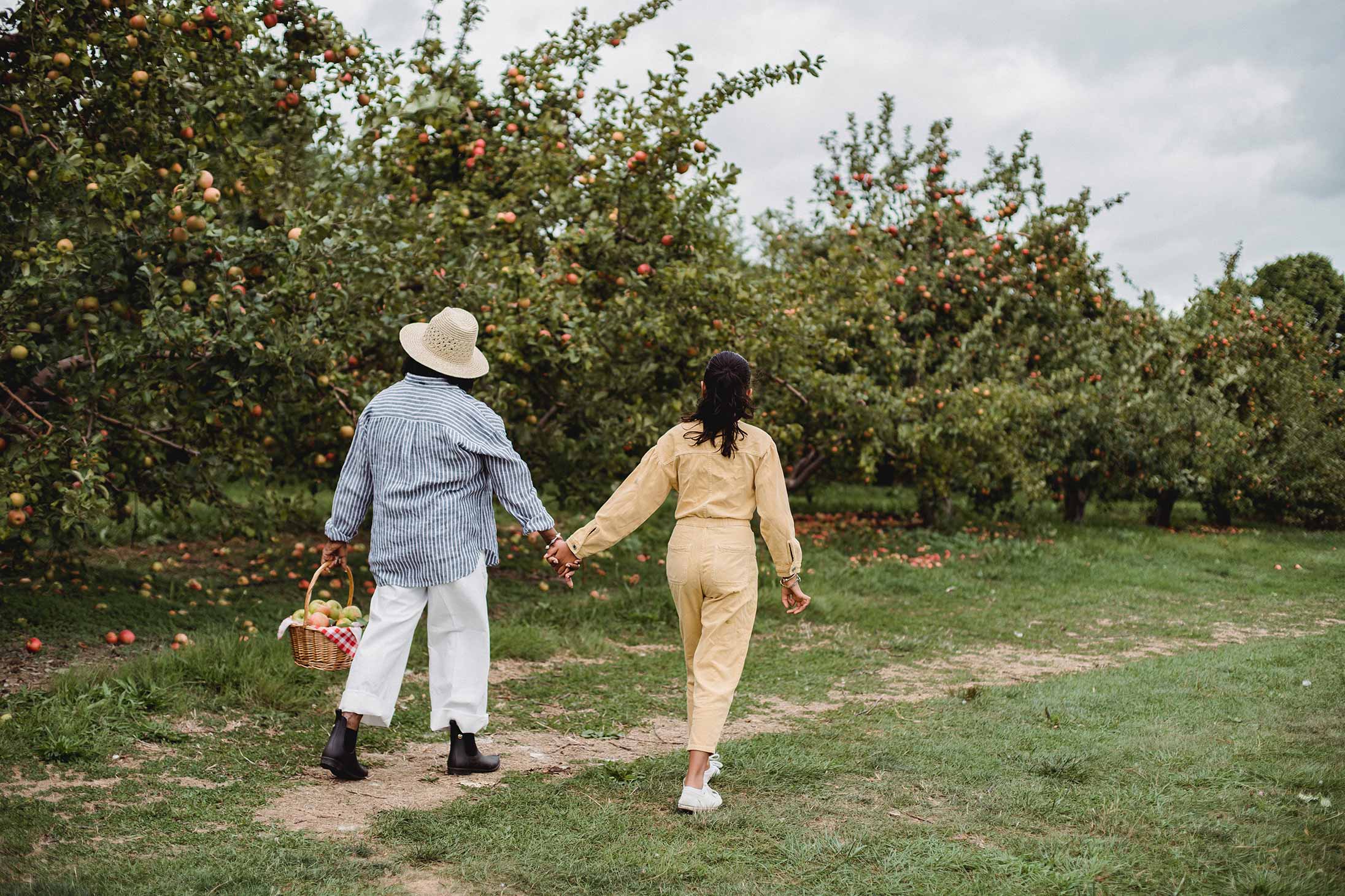 A young couple holding hands in a park in celebration of Mother's Day