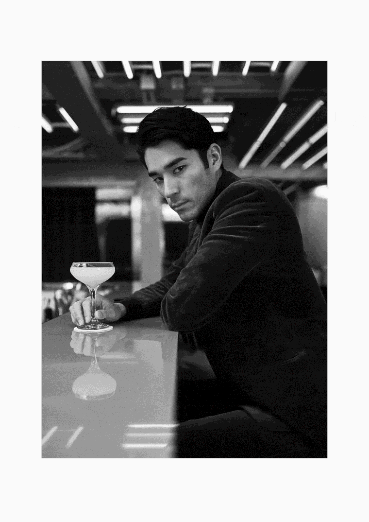 A model sips a cocktail at a bar wearing head-to-toe Hermès