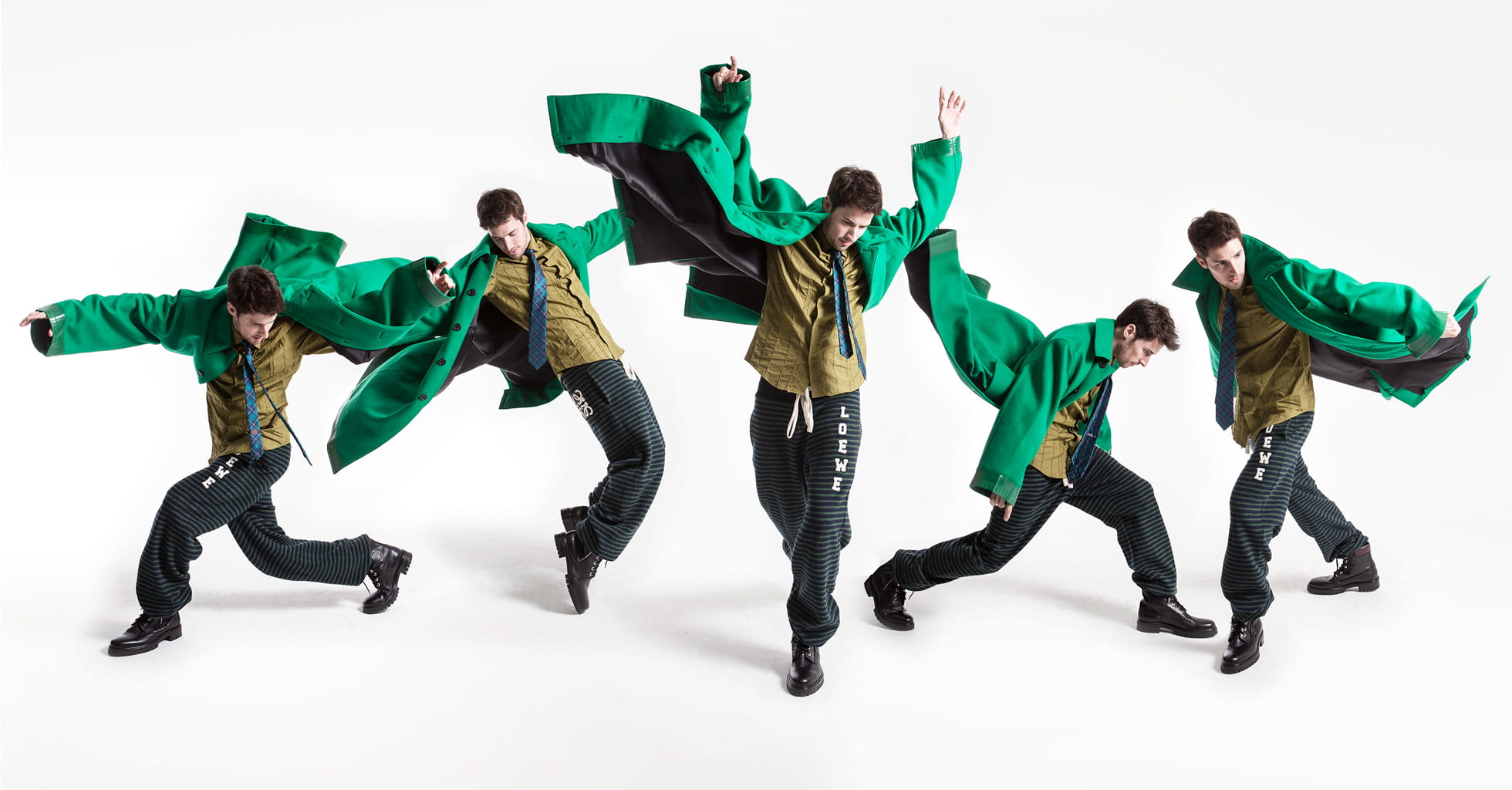 A model wears a festive green menswear coat from Prada