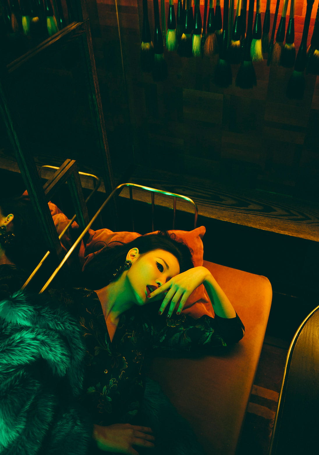 A model lounges in a decadent fur coat and printed jumpsuit