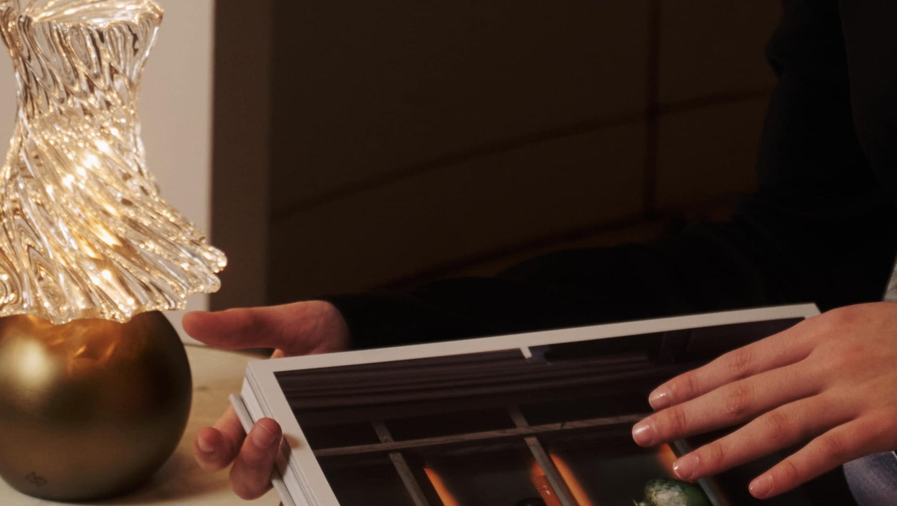 A woman reading with an Andre Fu lamp