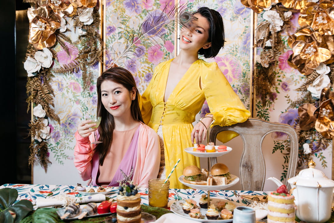 Anne wears Dries Van Noten and Laurawears Attico, available at Joyce Boutique. Canapés and tableware from Jouer.