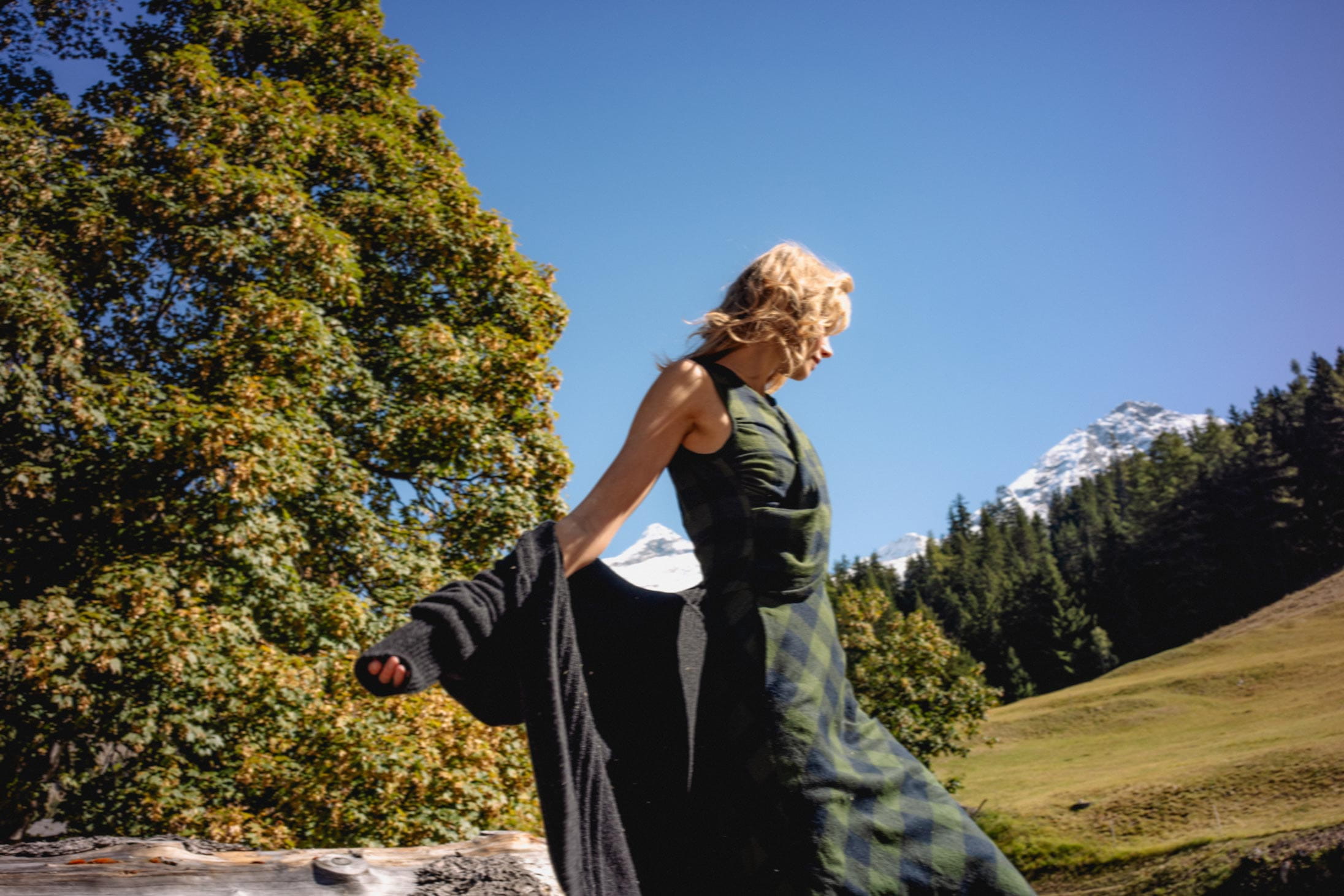 A model poses in the Swiss Alps wearing Longchamp and Hermès
