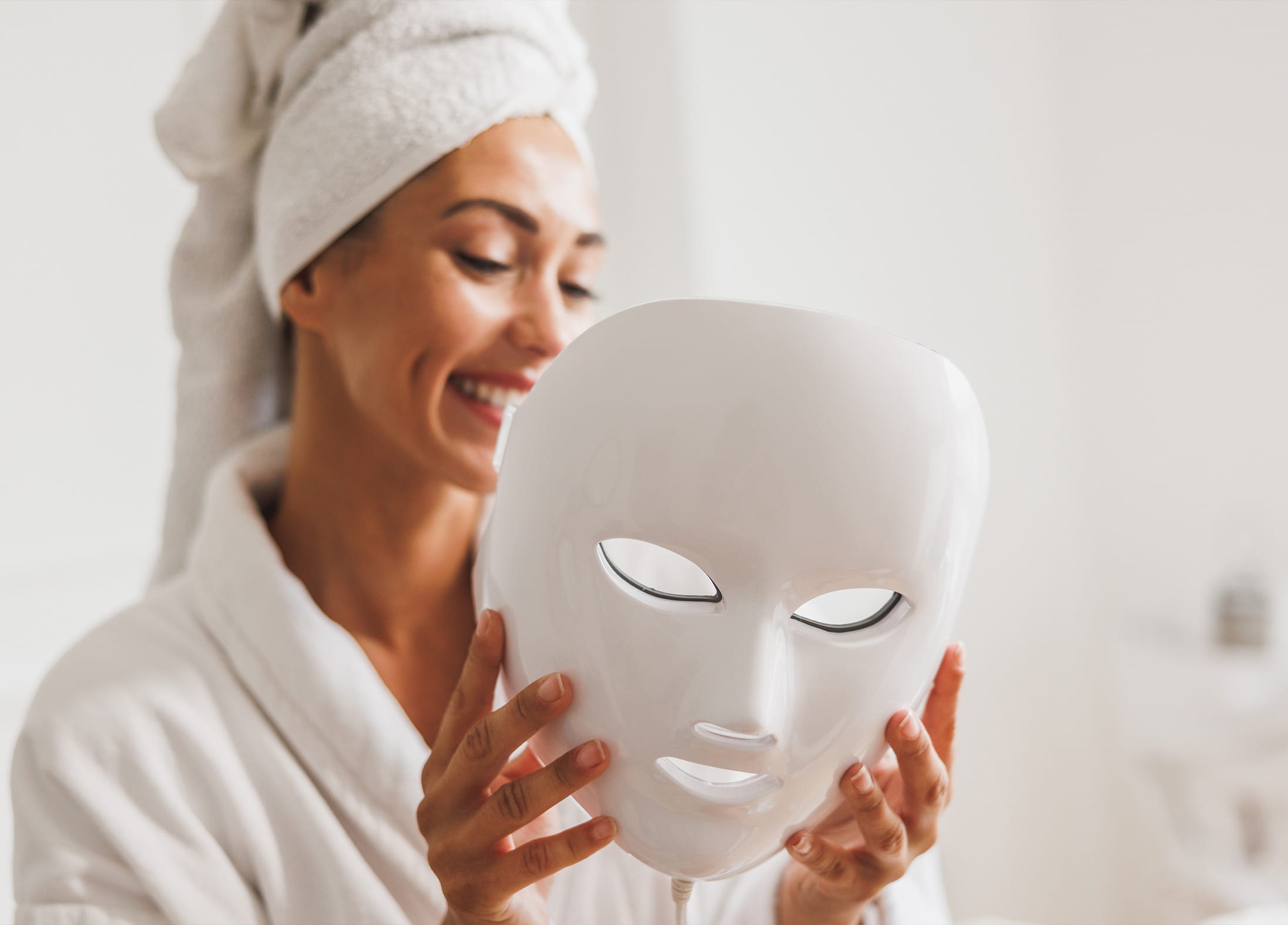 A woman preparing to use a light therapy mask